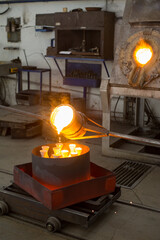 Workers molding shape in the foundry. Pouring melted metal.