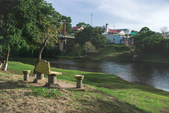 Bench at the river side with Hawkesworth suspension bridge crossing in San Ignacio, Belize