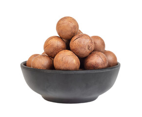 Heap of macadamia nuts in dark bowl isolated