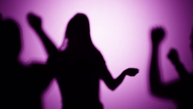 Shadows of dancing people on pink background. Silhouette of men and woman having disco party, celebrating, listening to music, night life, club.