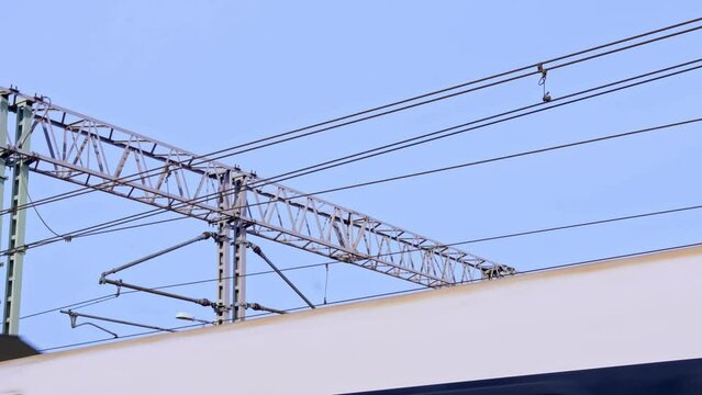 Electric Train Pantograph Sliding Along Overhead Power Lines on Railway Station