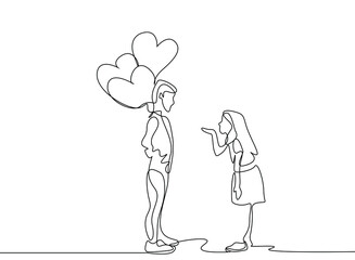 A teenage boy holding heart-shaped balloons with his hands behind his back is waiting to give it to the girl he loves. girl sending kisses to the boy she loves