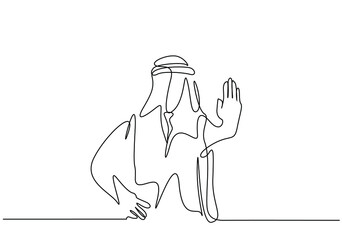 a muslim person in arabic clothes makes a stop sign with his hand