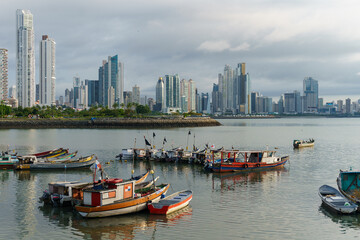 Fishing boats docked in front of modern skyscrapers in Casco Viejo Panama City