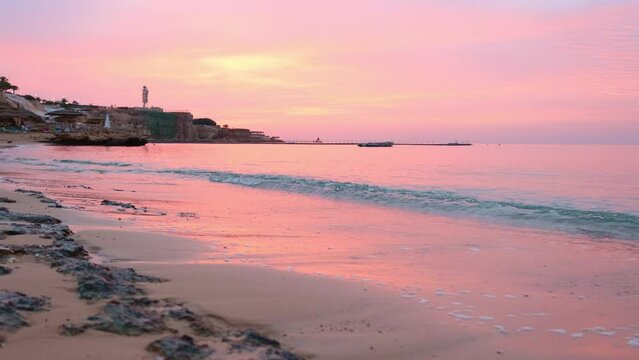 Panoramic view of beach Ras Umm El Sid. Beautiful sunrise over Red Sea with rocky shores, sandy beach with first rays of sun, Sharm El Sheikh, Egypt. Vacation, holiday concept. High quality 4k footage