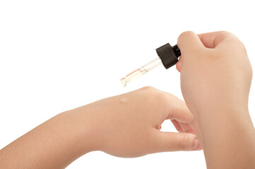 Skin care beauty concept. Dropping essential serum on hand on white background.