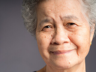 Close-up face of a smiling senior woman and looking at the camera