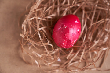 Top view, broken shell of an Easter egg in a nest on a beige background. Minimal concept. With space to copy. High quality photo