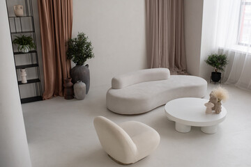 Part of large cozy and light living-room with white round table with handmade vases, comfortable...