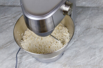 Kneading dough in the modern kitchen machine on a table