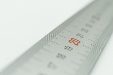 Iron ruler close-up on a white background. Stainless steel ruler. Working tools made of metal and stationery. Selective focus, isolated on white