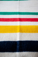 Detail of a bay blanket with green, red, yellow and blue stripes.