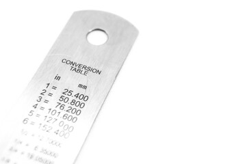 The reverse side of the metal ruler with a conversion table. Measuring ruler made of stainless...