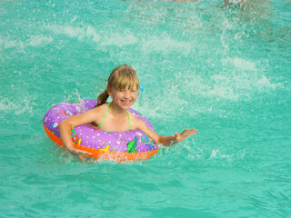 girl splashing in blue water with a circle