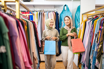 muslim female walking and holding shopping bag