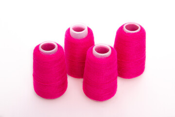 Pink spool of thread isolated on white background. Skein of woolen threads. Yarn for knitting. Materials for sewing machine. Coil