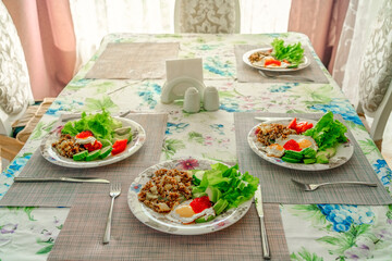 table with a served breakfast in the interior of the dining room , blurred background