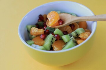 fruit salad of tangerines kiwi apples pomegranate seeds. healthy eating