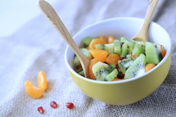fruit salad of tangerines kiwi apples pomegranate seeds. healthy eating
