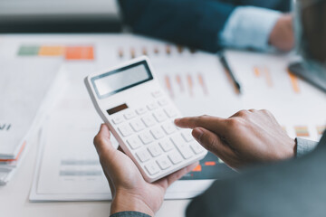 businessman accountant or financial consultant calculating income-expenditure and analysing real estate investment data in the office.
