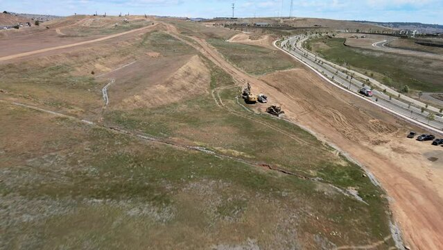 Aerial view over a construction project next to a freeway, road expansion