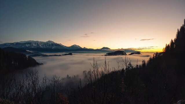 Bled Slovenia captured at sunrise with in the nature with beautiful mountains and landscapes cover in fog and nice golden hour colors filmed in a timelaps