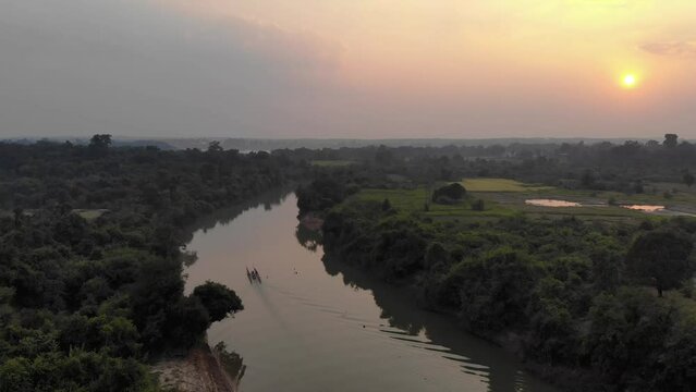 Aerial shot traveling alongside Mekong River at sunset, Pak Kading, Laos. Overcast day.