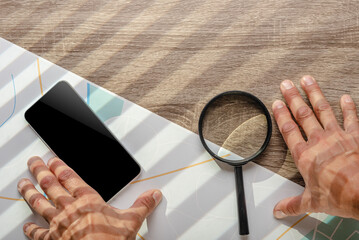 Policeman using magnifying glass with city map on the background