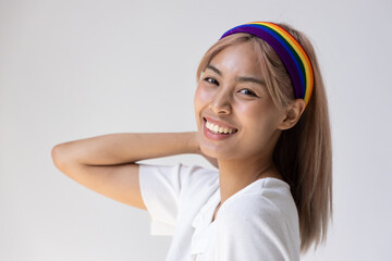 Happy LGBT woman wearing LGBTQ rainbow headband, concept of gay pride month, lesbian pride, LGBT awareness movement, non-binary inclusivity and diversity