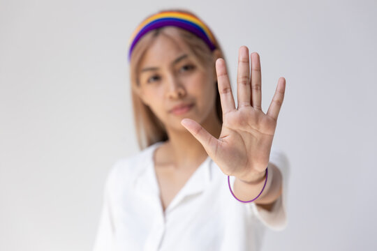 Modern LGBT woman showing stop hand gesture, concept of non-binary people acceptance, stop LGBT hate and misunderstandiing, rejecting discrimination against LGBT people or inclusivity and diversity