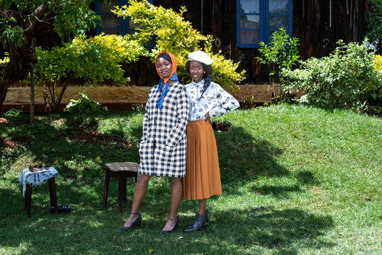 Portrait of two young African women in front of a rural home 