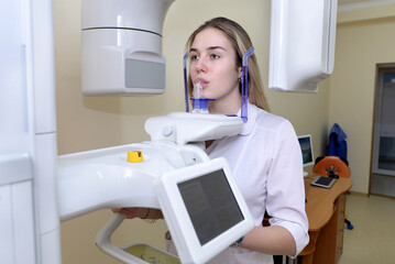 The dentist makes a panoramic digital x-ray of the teeth of the patient.