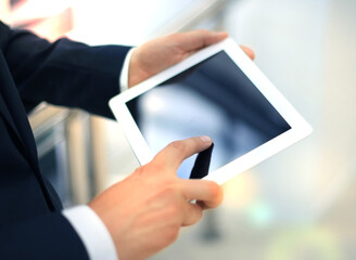 Midsection of businessman using digital tablet in office.