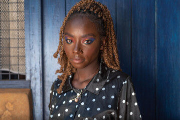 Portrait of young African woman against a blue door