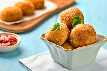 Bowl POTATO CROQUETTES on table close-up