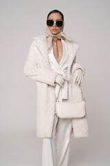 Beautiful young lady in a white faux fur coat - 488708348