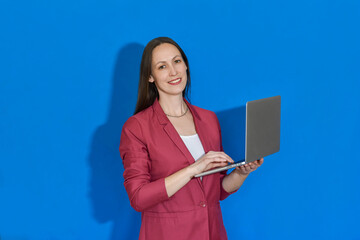 Woman girl holding a laptop on a blue background. Business woman. Distance learning online education and work.