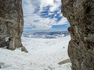 Winter views of the fascinating mountain range from the entrance of a cave in the peak mountains