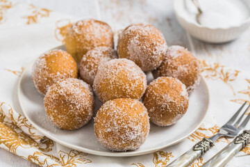 Fried curd balls with sugar on white wooden background. Concept of coffee break. Copy space.