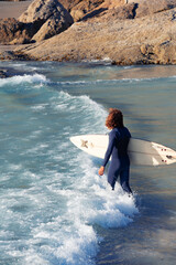 Surfer in blue ocean at sunset. Male surfer in sunny day.  Professional surfer in Cape Town, South Africa.Water sports. 