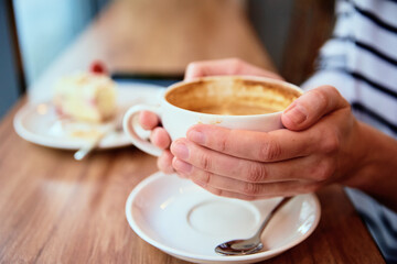 Woman have a breakfast at cafe, cup of coffee in woman hands, coffee break