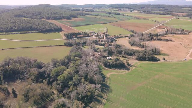 Aerial image of sown fields and a spectacular farmhouse in Girona province of Spain
