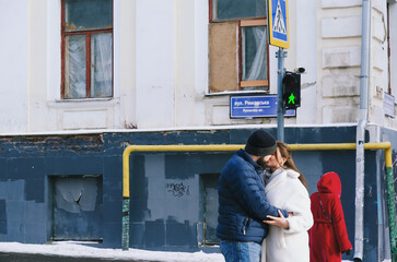 Love story of couple walking in city. Young business man in a blue jacket with a beard. And a cute woman in long coat. Family holiday and togetherness, date. Urban.