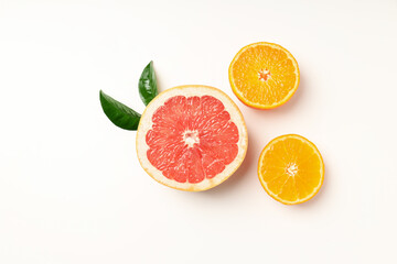 Citrus fruits with leaves on white background, top view