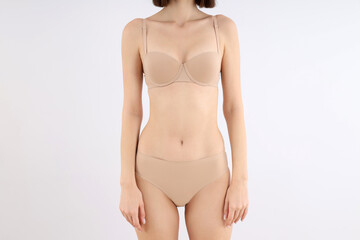 Fototapeta premium Concept of weight loss with young slim woman on light background