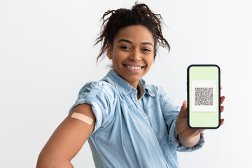 Black lady showing adhesive plaster on arm and digital certificate