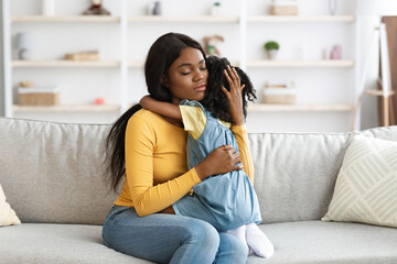 Caring African American Mom Comforting Upset Little Daughter At Home