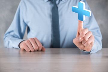 Obraz premium Businessman hold 3D plus icon, man hold in hand offer positive thing such as profit, benefits, development, CSR represented by plus sign.The hand shows the plus sign