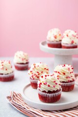 Red velvet cupcake with cream cheese frosting and red hearts sprinkles on the top. Valentine's Day concept. Selective focus.