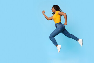 Excited african american woman running towards copy space